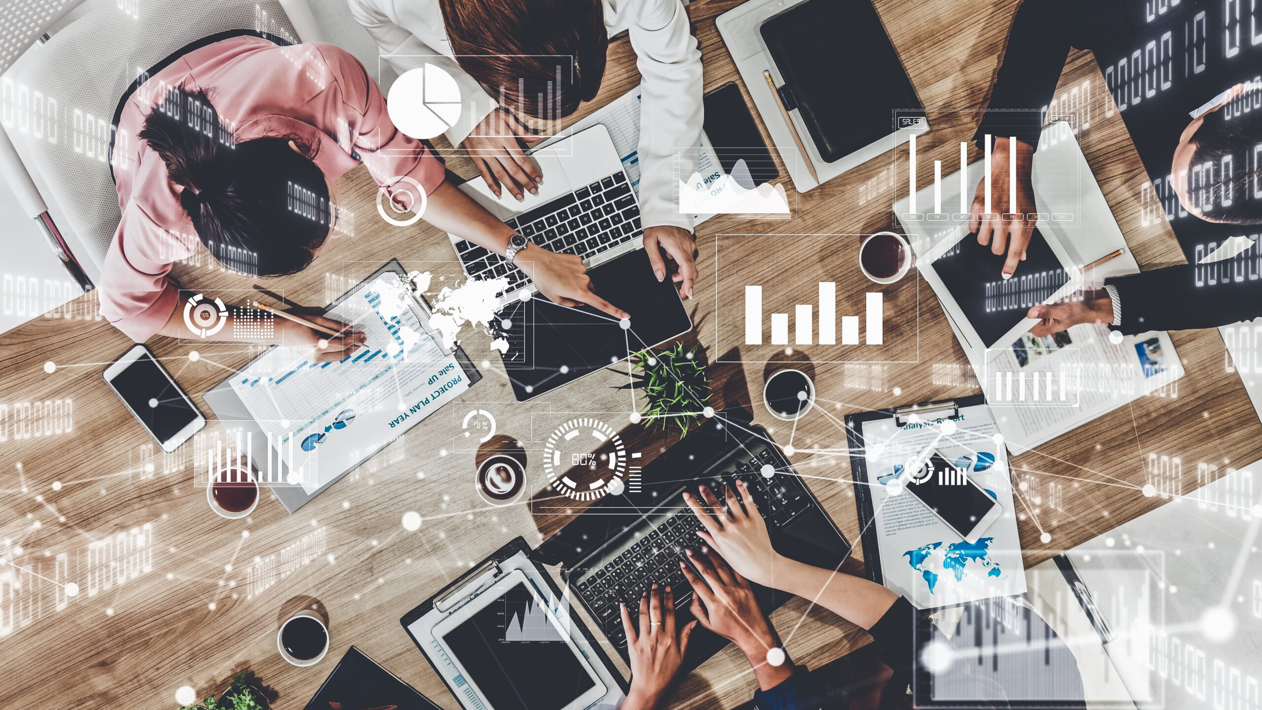 A group of professionals collaborating around a wooden office table, working on laptops, tablets, and documents. The image is overlaid with digital data visualizations, including bar charts, pie charts, network connections, and analytics graphics, representing technology, data analysis, and business strategy.